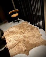 Gekleurd IJslands schapenvacht patchwork tapijt in camel op een donkere vloer