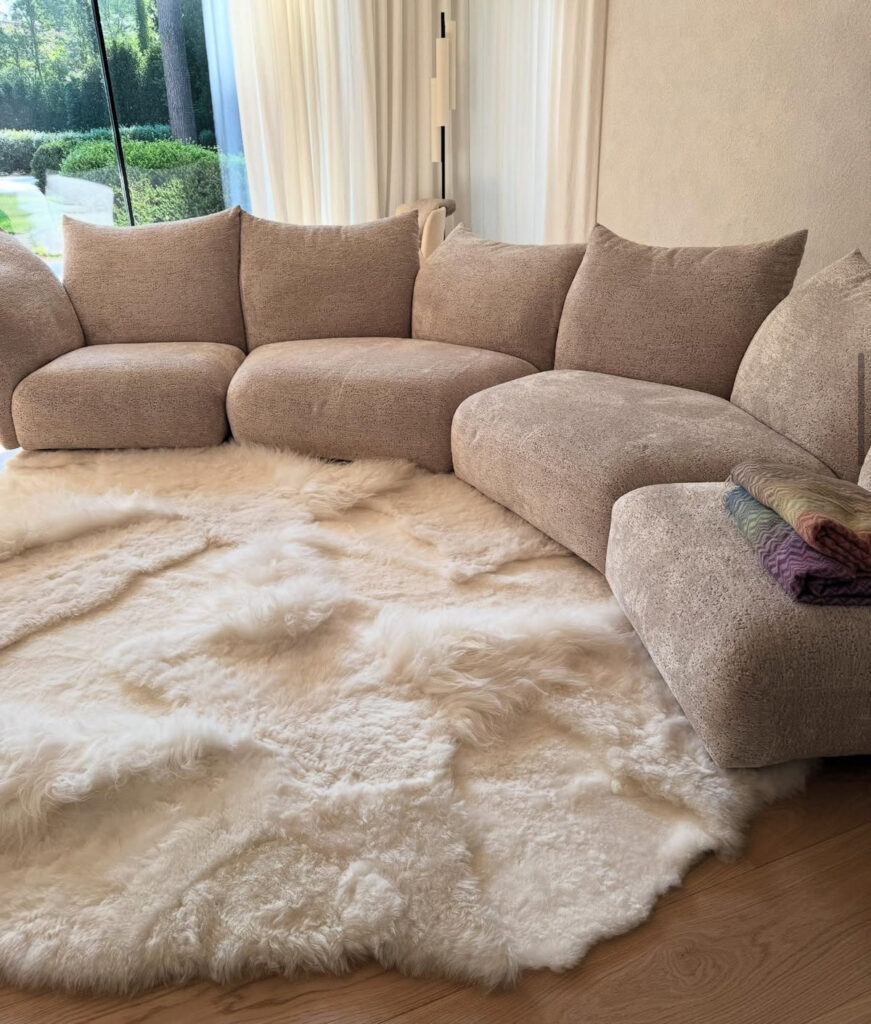 White patchwork sheepskin rug by Monroe Life in front of a beige corner sofa